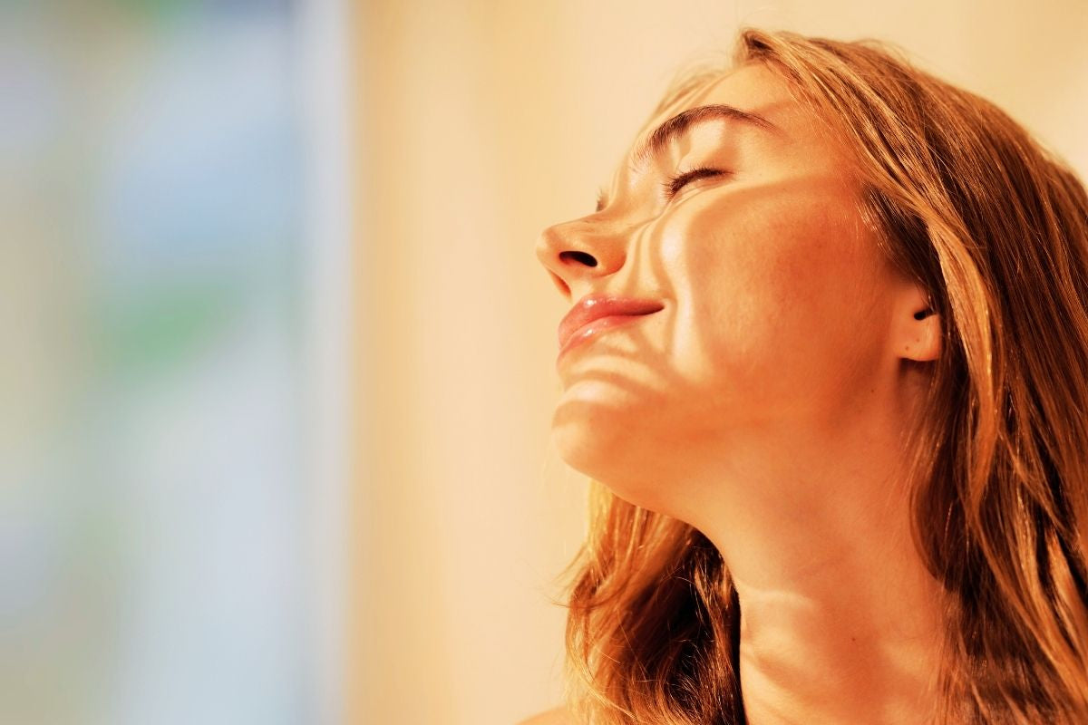 woman with eyes closed and sunlight on her face