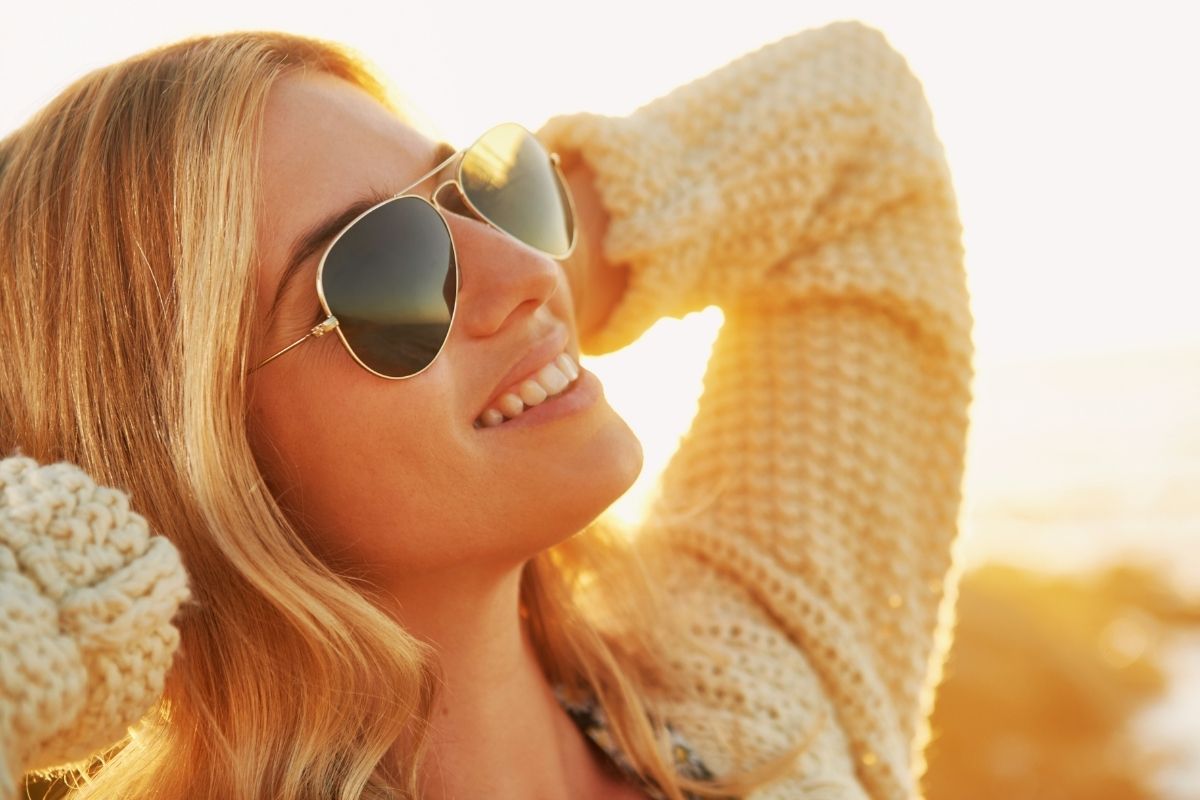 happy woman in sunglasses enjoying sunshine