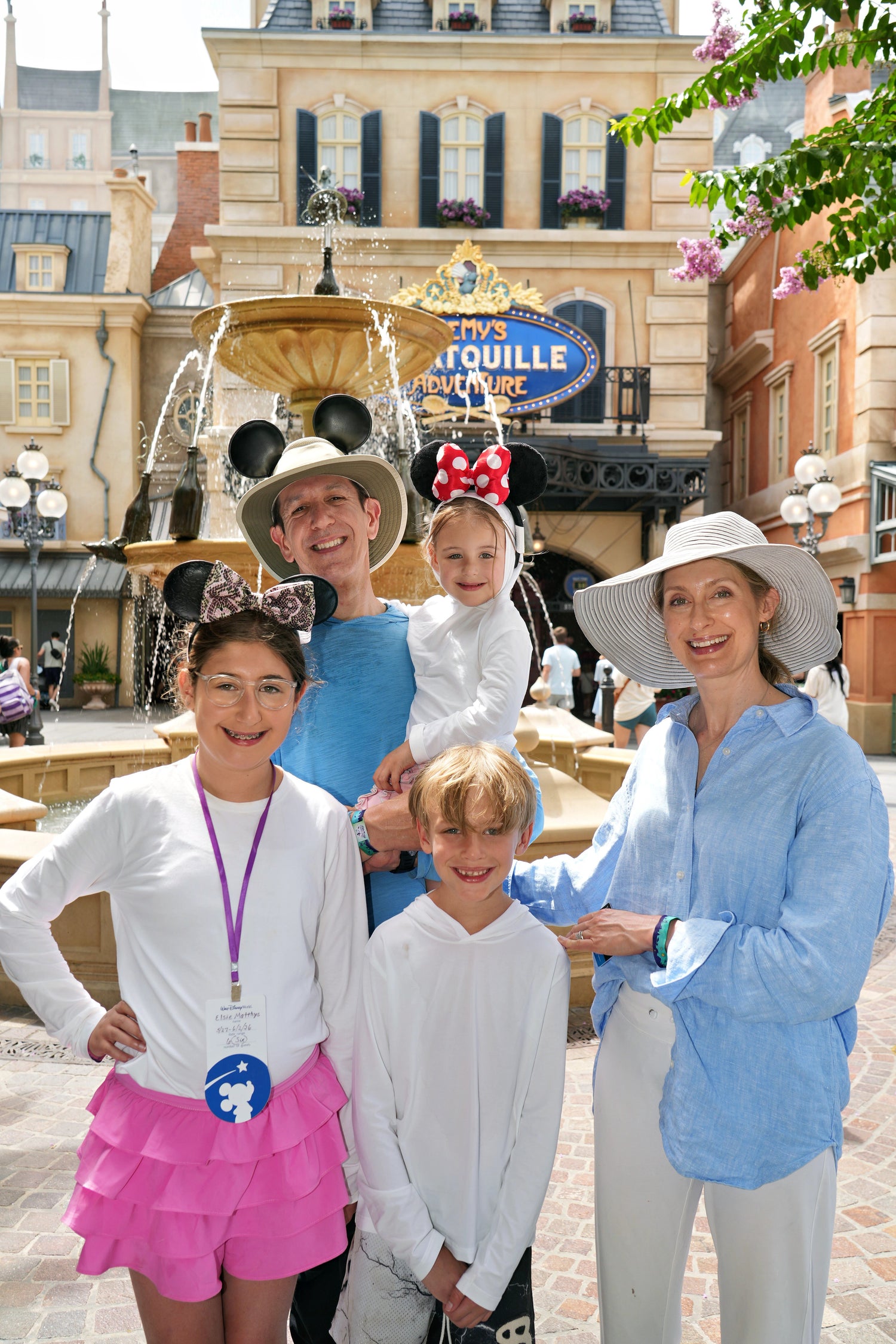 Dr. Matthys & Family in sunsafe clothing at Disney with fountain in the background