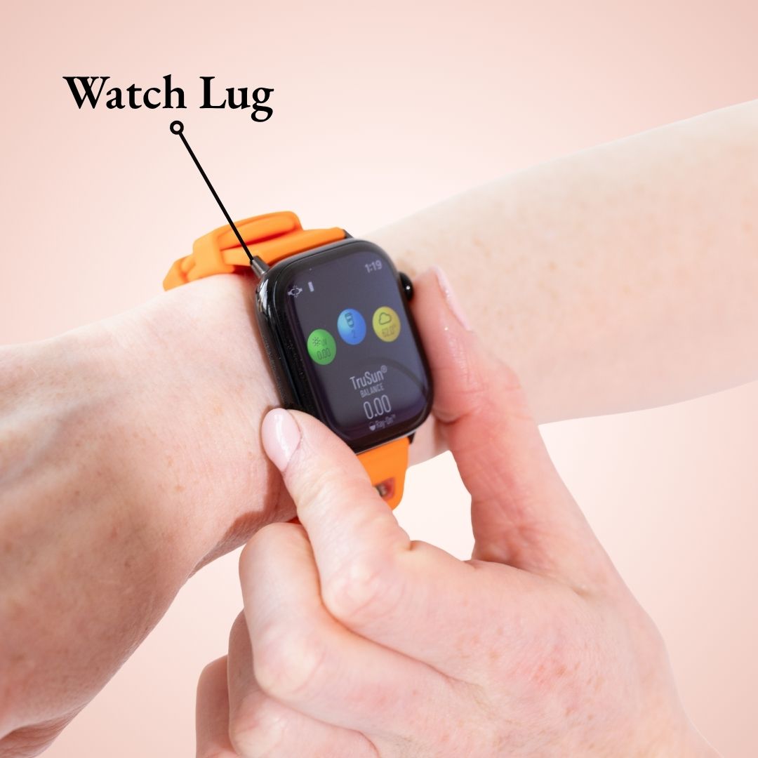 A close-up of the orange BURŪV smart band with fingers the text 'Watch Lug' pointing to black strap attachment area.