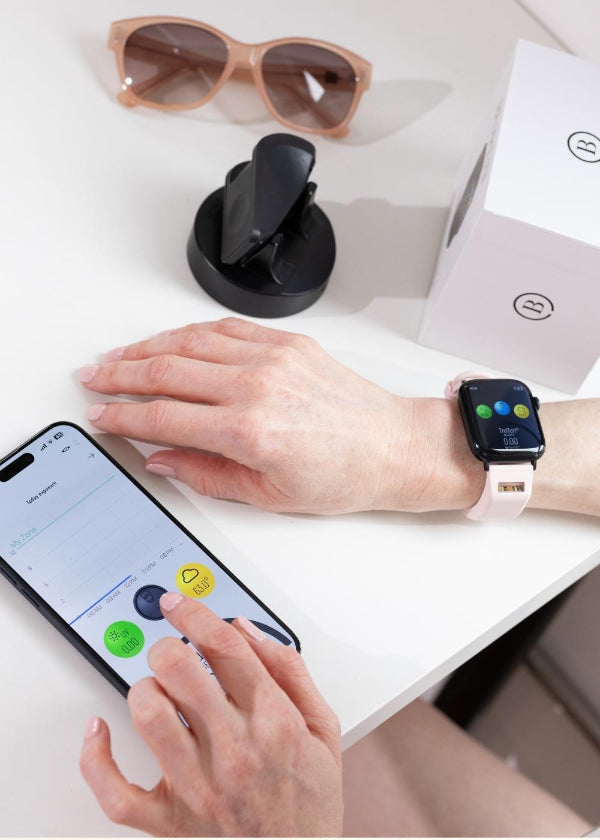 closeup of woman using BURŪV app and watch band on white desk
