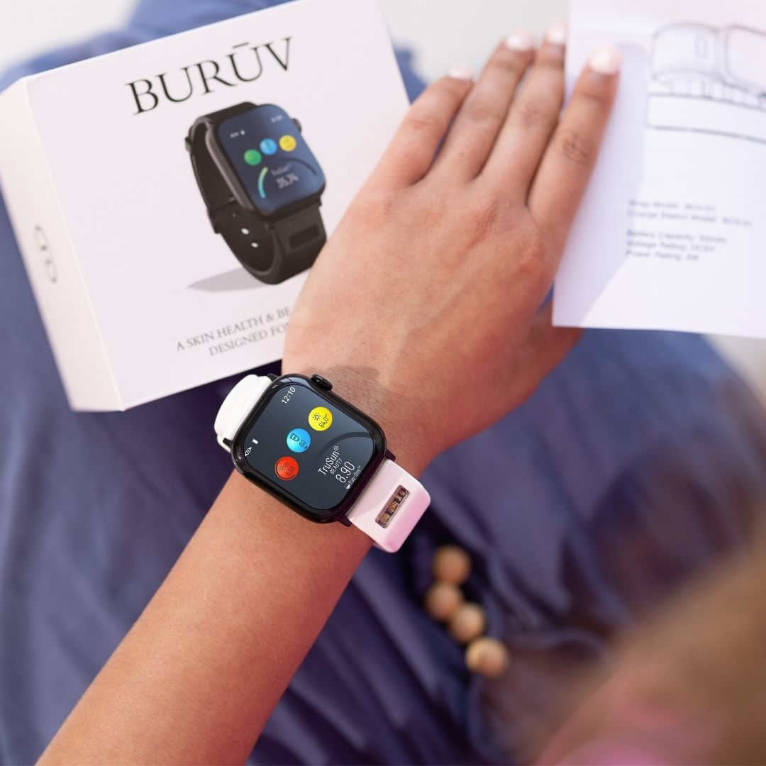 Woman in blue dress wearing white BURŪV smart band with box and instructions